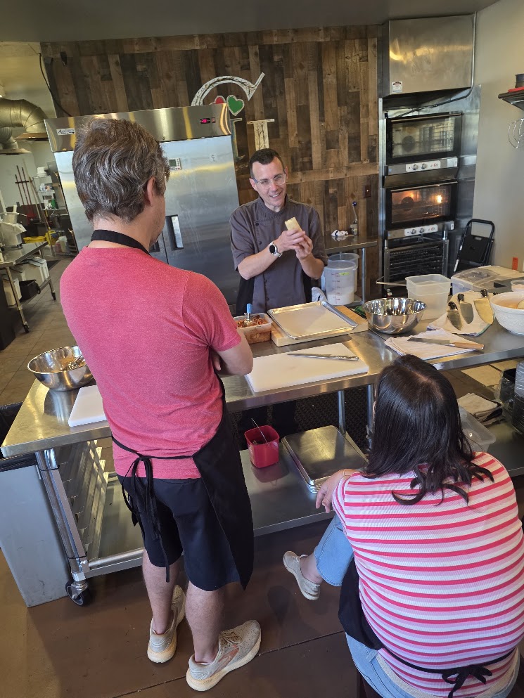 Chef John demonstrating tamale making during a hands-on class at the studio